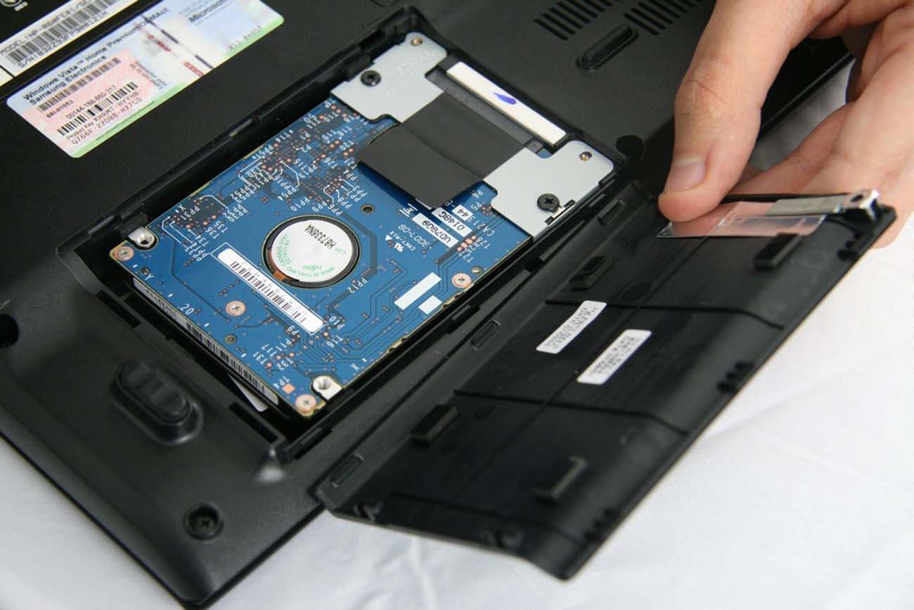 Мастер производит замену жесткого диска в ноутбуке
